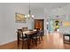 Inviting dining room features wood flooring, a chandelier, and an open entrance, creating a warm and welcoming space at 541 Carrera Dr, The Villages, FL 32159
