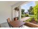 Covered front porch features an outdoor seating area with views of the front yard landscaping and water feature at 541 Carrera Dr, The Villages, FL 32159