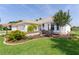 Well-maintained lawn of single story home with attached garage, landscaping, and a front yard water fountain feature at 541 Carrera Dr, The Villages, FL 32159