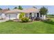 Charming single-story home featuring lush green lawn and landscaping with a water fountain feature at 541 Carrera Dr, The Villages, FL 32159