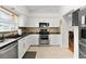 Modern kitchen featuring stainless steel appliances, white cabinetry and black countertops at 541 Carrera Dr, The Villages, FL 32159
