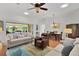 Bright and airy living room with comfortable sofas, ceiling fan, and access to a dining area and outdoor views at 541 Carrera Dr, The Villages, FL 32159