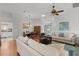 Bright living room featuring hardwood floors, a ceiling fan, and a dining area in the background at 541 Carrera Dr, The Villages, FL 32159