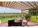 Cozy outdoor patio area with a pergola, a table, chairs, and a view of the lush green lawn at 541 Carrera Dr, The Villages, FL 32159
