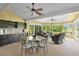 Bright sunroom with dining and seating areas, ceiling fans, bar area, and expansive outdoor views at 541 Carrera Dr, The Villages, FL 32159