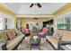 Spacious sunroom with dining and seating areas, ceiling fans, bar area, and expansive outdoor views at 541 Carrera Dr, The Villages, FL 32159