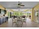 Bright sunroom with dining and seating areas, ceiling fans, bar area, and expansive outdoor views at 541 Carrera Dr, The Villages, FL 32159