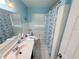 Bright bathroom features a single sink vanity and a shower with decorative curtain at 603 W Seminole Ave, Eustis, FL 32726