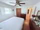 Well-lit bedroom with a ceiling fan, closet, and views of the backyard at 603 W Seminole Ave, Eustis, FL 32726