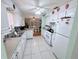 An open kitchen with white cabinets, appliances, and tile flooring at 603 W Seminole Ave, Eustis, FL 32726