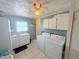 Bright laundry room features a washer, dryer, storage cabinets, and a sink with ample counter space at 603 W Seminole Ave, Eustis, FL 32726