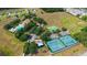 Panoramic view of the community with pool, tennis courts, and lush greenery from above at 6042 Claystone Way, Mount Dora, FL 32757