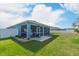 Back exterior view of screened-in porch and backyard with white vinyl fence at 6042 Claystone Way, Mount Dora, FL 32757