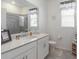 Modern bathroom with large mirror, white cabinets and drawers and glass shower at 6042 Claystone Way, Mount Dora, FL 32757