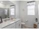 Bathroom featuring a big mirror, white cabinets, toilet, and a walk-in shower at 6042 Claystone Way, Mount Dora, FL 32757