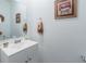 Clean, simple powder room with white vanity and decorative mirror at 6042 Claystone Way, Mount Dora, FL 32757