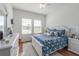 Cozy bedroom featuring two windows, wooden floors, and white painted furnishings at 6042 Claystone Way, Mount Dora, FL 32757