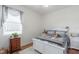 Bedroom with a dresser and a window, plush rug, and white trim furnishings at 6042 Claystone Way, Mount Dora, FL 32757