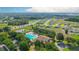 Aerial view of community pool area with a fountain, clubhouse, and lush landscaping at 6042 Claystone Way, Mount Dora, FL 32757