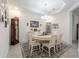 Bright dining room featuring a white table, chandelier, and decorative accents on a patterned rug at 6042 Claystone Way, Mount Dora, FL 32757