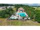 Aerial view of community pool with palm trees, splash pad, and lounge chairs, perfect for relaxation at 6042 Claystone Way, Mount Dora, FL 32757