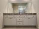 Bathroom vanity with granite countertop, white cabinets, double sinks, and a large mirror at 6203 Sw 93Rd Loop, Ocala, FL 34476