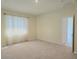 Spacious bedroom with neutral carpet, natural light and an open doorway to another room at 6203 Sw 93Rd Loop, Ocala, FL 34476