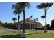 Community clubhouse featuring flags and palm trees, perfect for community events at 6203 Sw 93Rd Loop, Ocala, FL 34476