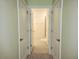 Hallway with double doors open to bathroom with tiled floor, shower, and toilet at 6203 Sw 93Rd Loop, Ocala, FL 34476