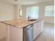 Kitchen island featuring granite countertop, white cabinetry, stainless steel dishwasher, and a stainless steel sink at 6203 Sw 93Rd Loop, Ocala, FL 34476