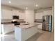 Bright kitchen featuring white cabinets, stainless steel appliances, a center island, and granite countertops at 6203 Sw 93Rd Loop, Ocala, FL 34476