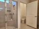 Walk-in shower with glass door and built-in niche, next to opened door to toilet at 6203 Sw 93Rd Loop, Ocala, FL 34476