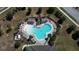 Aerial view of a large, uniquely shaped community pool surrounded by lounge chairs and lush landscaping at 6203 Sw 93Rd Loop, Ocala, FL 34476
