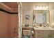 This bathroom features a combination shower and tub with pastel pink tiling and neutral wallpaper at 621 High Point Dr, Mount Dora, FL 32757