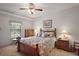 Cozy bedroom with a ceiling fan, floral bedding, and ample natural light at 621 High Point Dr, Mount Dora, FL 32757