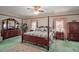 Spacious bedroom featuring a four-poster bed, carpeted floors, and matching furniture at 621 High Point Dr, Mount Dora, FL 32757