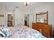 Cozy bedroom with wood furniture, a floral bedspread and ensuite bath at 621 High Point Dr, Mount Dora, FL 32757