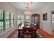 Elegant dining room with hardwood floors, a chandelier, and large windows, providing a sophisticated setting for meals at 621 High Point Dr, Mount Dora, FL 32757