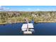 Aerial view of boat dock on a tranquil lake surrounded by lush greenery, offering serene waterfront living at 621 High Point Dr, Mount Dora, FL 32757