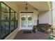 Inviting entry with double glass doors, brick-paved porch, and decorative accents, enhanced by natural light from large windows at 621 High Point Dr, Mount Dora, FL 32757