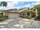 This large two-car garage boasts ample parking on a long driveway and well-manicured front yard at 621 High Point Dr, Mount Dora, FL 32757