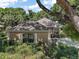 Tan home with landscaped front yard and mature shade trees giving a verdant surrounding to the property at 621 High Point Dr, Mount Dora, FL 32757