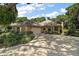 A charming home with a beige exterior, lush landscaping, and a well-maintained driveway, set beneath a beautiful blue sky at 621 High Point Dr, Mount Dora, FL 32757
