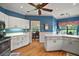 View of the kitchen with white cabinets, wood flooring, and breakfast nook at 621 High Point Dr, Mount Dora, FL 32757