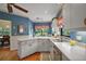Kitchen featuring white cabinets, wooden floors, and view of dining room at 621 High Point Dr, Mount Dora, FL 32757