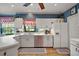 Bright kitchen with white cabinets, stainless steel appliances, and view of the yard at 621 High Point Dr, Mount Dora, FL 32757