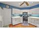 View of the kitchen with white cabinets and stainless steel appliances at 621 High Point Dr, Mount Dora, FL 32757