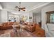 Open-concept living room with ceiling fan, hardwood floors, and stylish furniture, offering a modern and comfortable environment at 621 High Point Dr, Mount Dora, FL 32757