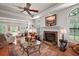 Bright living room with fireplace, large windows, and classic decor, featuring hardwood floors and comfortable seating at 621 High Point Dr, Mount Dora, FL 32757