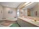 Well-lit main bathroom featuring a large mirror, bathtub and double sink vanity at 621 High Point Dr, Mount Dora, FL 32757